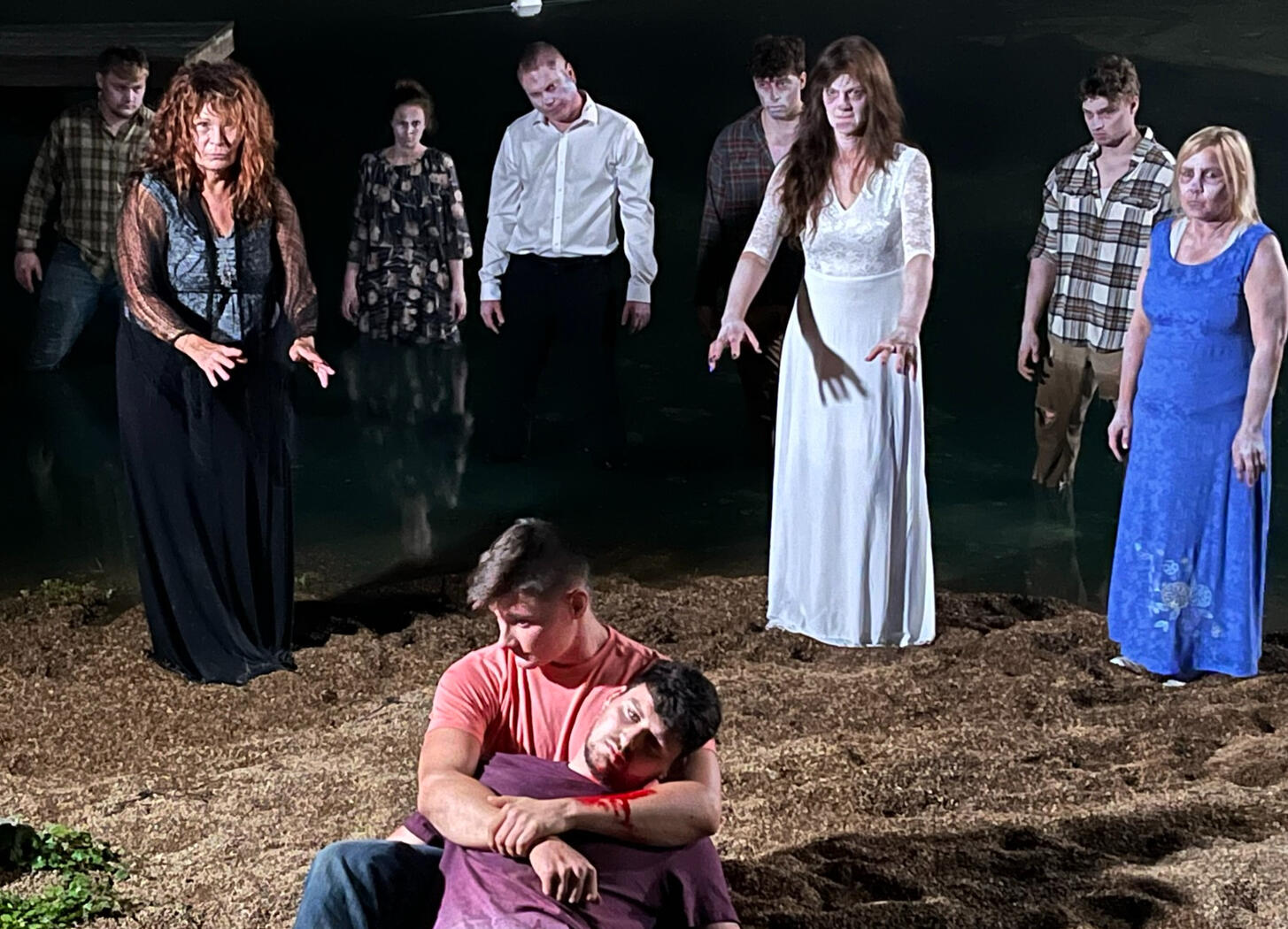 Zombies encircling two men, one dying